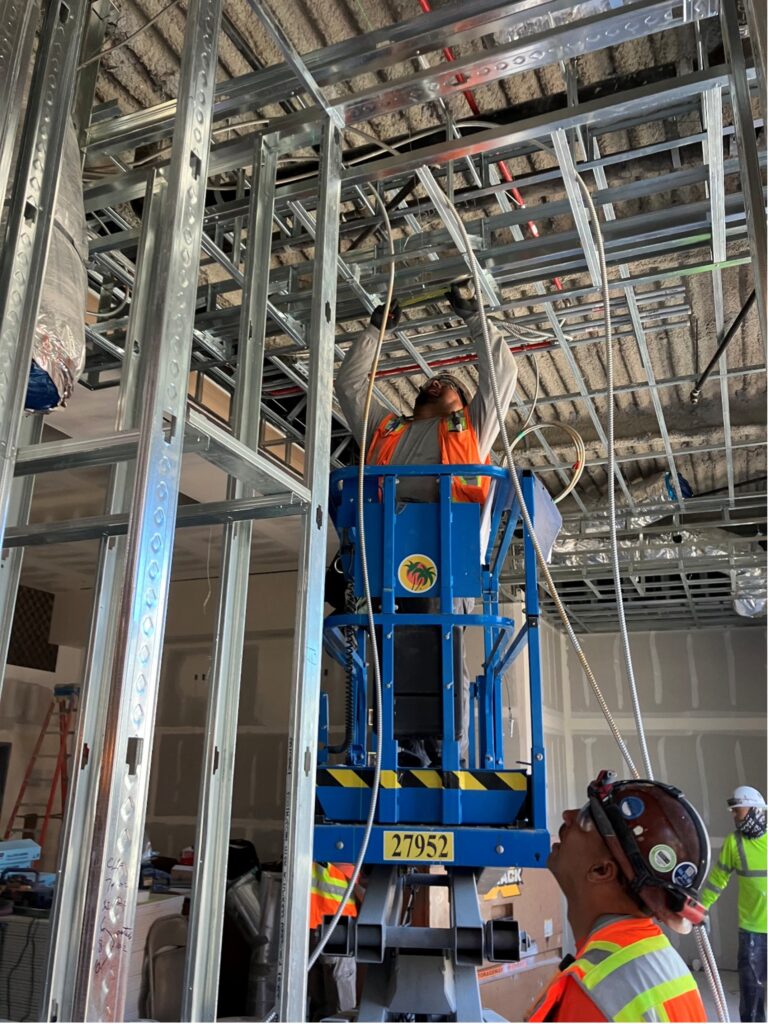 Neal Electric worker on top of a aerial work platform doing electrical work